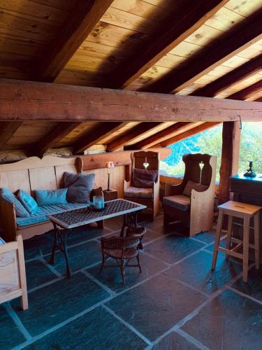 un salon avec un canapé, une table et des chaises dans l'établissement L'Agneau Rouge - Charmant appartement avec terrasse, à Séez