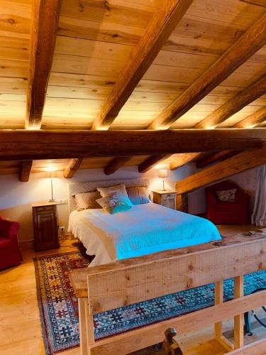 un lit dans une chambre avec un plafond en bois dans l'établissement L'Agneau Rouge - Charmant appartement avec terrasse, à Séez