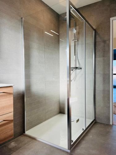 une douche avec une porte vitrée dans une salle de bain dans l'établissement Jolie maison neuve Nantes-Zola, à Nantes