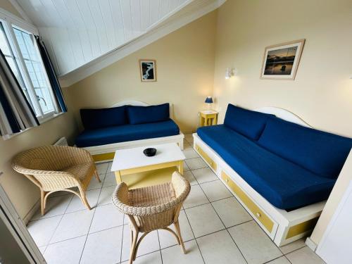 ein Schlafzimmer mit einem Bett und zwei Stühlen und einem Tisch in der Unterkunft "LE VENDEE GOLF" Appartement 8 personnes, vue golf, accès piscines gratuit, village vacances in Talmont