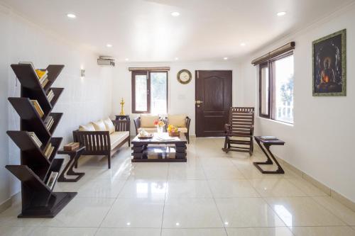 una sala de estar con un sofá y una mesa en Alaya Stays Madhuram Pet-Friendly Hillside Retreat With Garden & Balcony, en Dehradun
