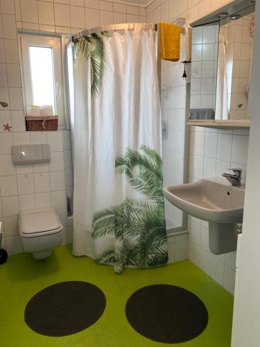 a bathroom with a shower curtain with a green floor at Casa Pippi Lotta in Gießen