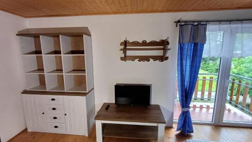 a room with a book shelf and a desk and a window at Penzion Slunečno in Dobšín