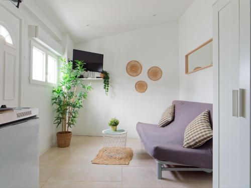 un salon avec un canapé violet et des plantes dans l'établissement Studio avec jardinet, à Martigues