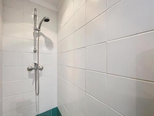 une douche dans une salle de bain avec du carrelage blanc dans l'établissement Havre d'Esther, à Nancy