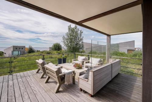 eine Terrasse mit Tisch und Stühlen auf einem Deck in der Unterkunft Exclusive Duin Villa - 6p - Direct bij Natuur & Strand - Villa 70 in Ouddorp