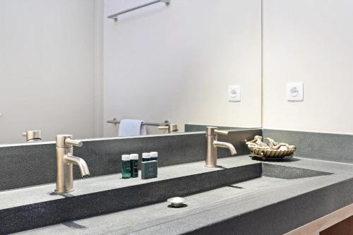 a bathroom with a sink and a mirror at Luxury Waterfront Retreat 4p - Comfort & Panoramisch Uitzicht - Villa 13 in Ouddorp