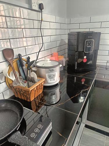 a kitchen counter with a coffee pot and a coffee maker at SR Kampar 2-Storey LANDED HOMESTAY in Kampar
