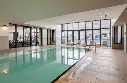 a large swimming pool in a building with windows at ES2410-2Bed 2Bath Vision Apt with Balcony, Pool & Gym in Melbourne
