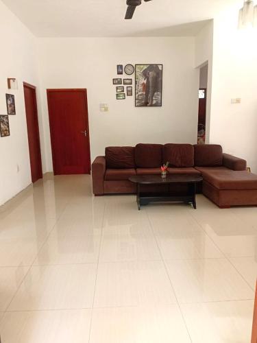 a living room with a brown couch and a coffee table at Guesthouse Dilush in Beruwala