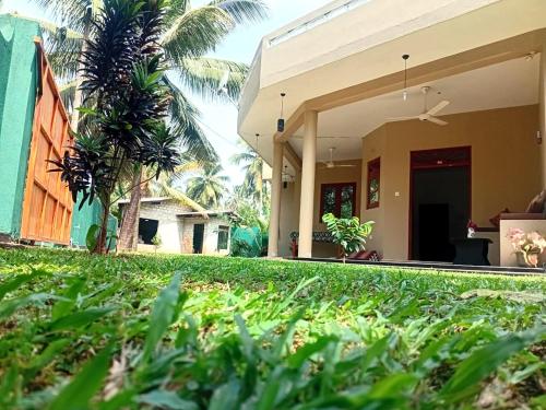 a view of a house with a yard at Guesthouse Dilush in Beruwala