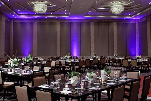 a banquet hall with tables and chairs and purple lighting at Renaissance Dallas at Plano Legacy West Hotel in Plano
