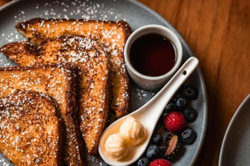 a plate of french toast with a cup of coffee and berries at Renaissance Dallas at Plano Legacy West Hotel in Plano