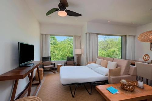 a living room with a couch and a tv at El Mangroove Papagayo, Autograph Collection in Papagayo, Guanacaste