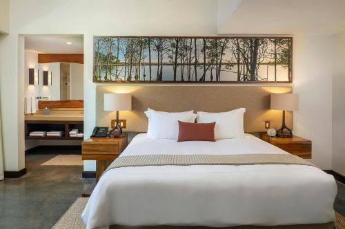 a bedroom with a large bed and a bathroom at El Mangroove Papagayo, Autograph Collection in Papagayo, Guanacaste