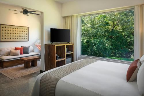 a bedroom with a bed and a large window at El Mangroove Papagayo, Autograph Collection in Papagayo, Guanacaste