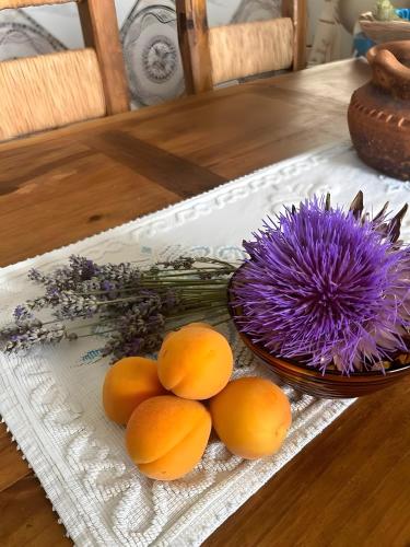 a plate of oranges and a purple flower on a table at K-Rooms in Veli Iž