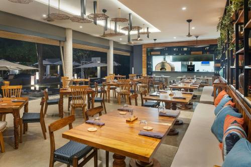 a restaurant with wooden tables and chairs at El Mangroove Papagayo, Autograph Collection in Papagayo, Guanacaste
