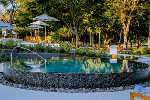 a pool at a resort with chairs and trees at El Mangroove Papagayo, Autograph Collection in Papagayo, Guanacaste