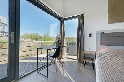 a bedroom with a desk and a bed and a window at Super VIP Waterfront Villa - 4p - Waterzicht & Windbeschut Terras - Villa 42 in Ouddorp