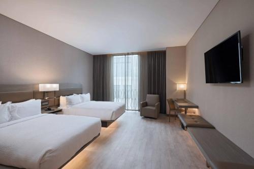 a hotel room with two beds and a flat screen tv at AC Hotels by Marriott Guatemala City in Guatemala