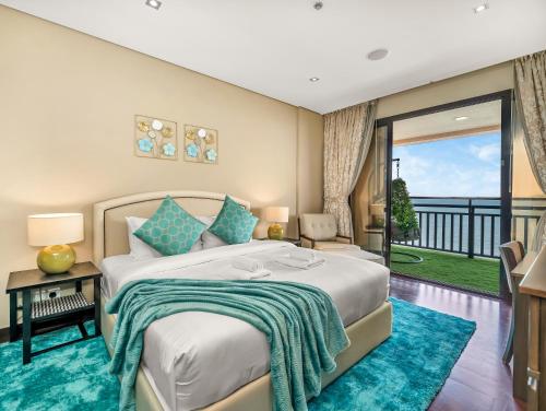 a bedroom with a large bed and a balcony at Luxury Apartments in Anantara Resort with Stunning Burj AlArab & Sea Views in Dubai