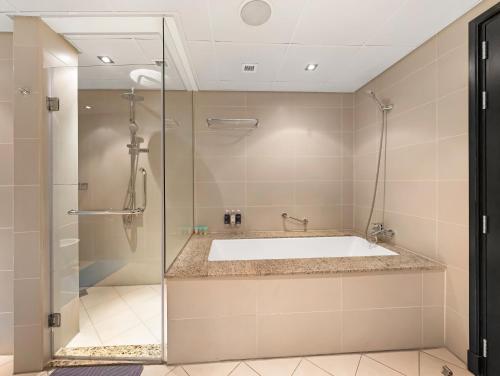 a bathroom with a tub and a shower at Luxury Apartments in Anantara Resort with Stunning Burj AlArab & Sea Views in Dubai