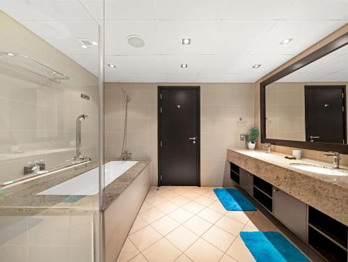 a bathroom with two sinks and a large mirror at Luxury Apartments in Anantara Resort with Stunning Burj AlArab & Sea Views in Dubai