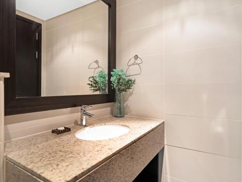 a bathroom with a sink and a mirror at Luxury Apartments in Anantara Resort with Stunning Burj AlArab & Sea Views in Dubai