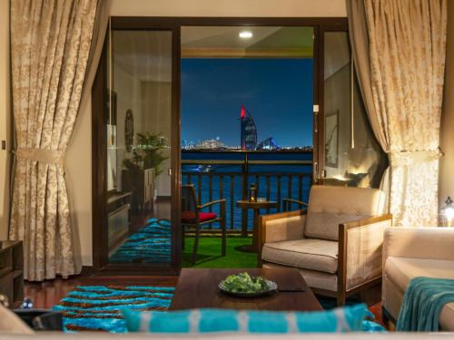 a living room with a view of the water at Luxury Apartments in Anantara Resort with Stunning Burj AlArab & Sea Views in Dubai