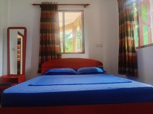 a bedroom with a bed and a window with curtains at Guesthouse Dilush in Beruwala