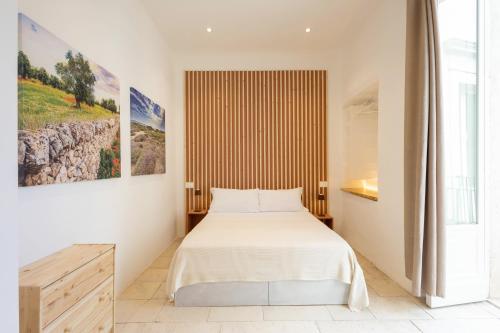 a bedroom with a bed and a large window at Palazzo Kapece in Monopoli