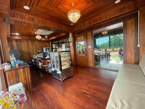 ein Zimmer mit Holzböden und einem Geschäft mit einer Theke in der Unterkunft Ruen Singhanat Cafe & Resort in Ban Lum Thonglang (2)