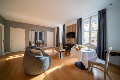 a living room with a table and a chair at Hôtel Château Schengen in Schengen