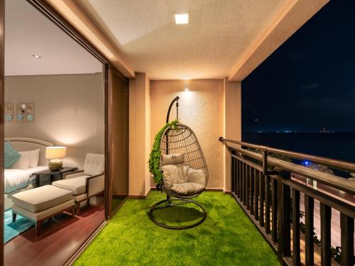 a balcony with a swing and a room with a bed at Luxury Apartments in Anantara Resort with Stunning Burj AlArab & Sea Views in Dubai