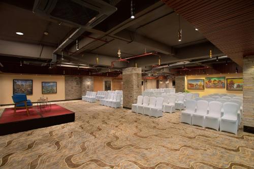 a room with white chairs and tables in it at Aloft Kathmandu Thamel in Kathmandu