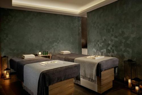 two beds in a room with green walls at Montcalm East, Autograph Collection in London