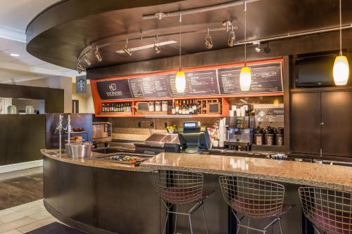 a bar in a restaurant with a counter with bar stools at Courtyard Clemson in Clemson