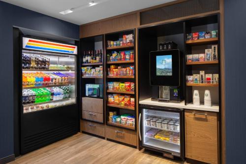 a grocery store with a refrigerator and a television at Courtyard by Marriott Lansing Downtown in Lansing