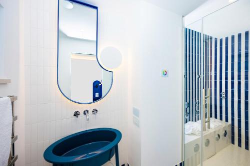 a bathroom with a blue toilet and a mirror at Pepella in Piano di Sorrento