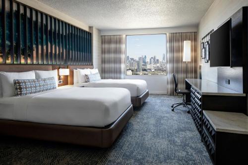 a hotel room with two beds and a large window at Renaissance Dallas Hotel in Dallas