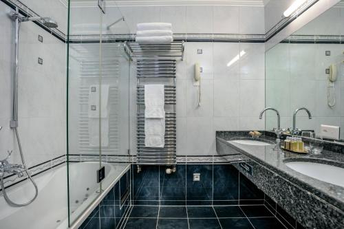 a bathroom with two sinks and two mirrors at Grand Hotel Suisse Majestic, Autograph Collection in Montreux