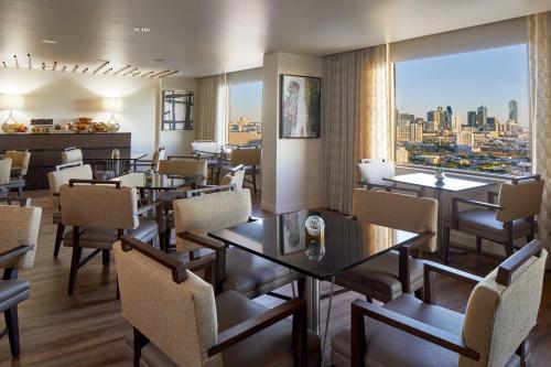 a restaurant with tables and chairs and a view of the city at Renaissance Dallas Hotel in Dallas