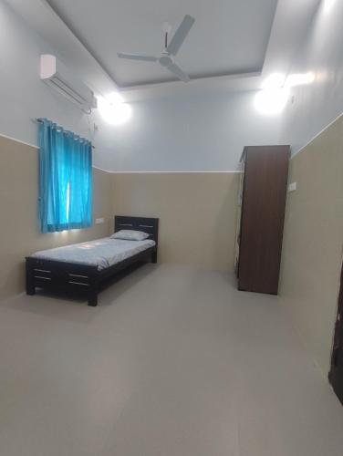 a bedroom with a bed and a blue curtain at RK mahal & residency in Dindigul