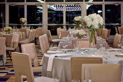 a room with tables and chairs with vases of flowers at Renaissance Dallas Hotel in Dallas