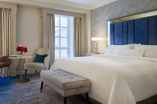 a hotel room with a large bed and a desk at The College Green Dublin Hotel, Autograph Collection in Dublin