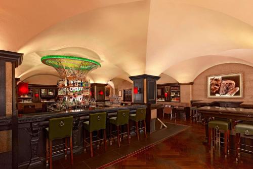 a bar in a restaurant with green bar stools at The College Green Dublin Hotel, Autograph Collection in Dublin