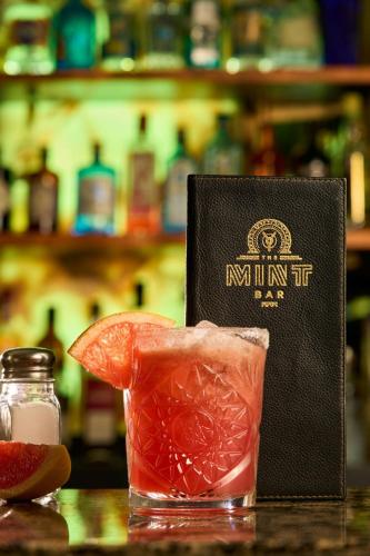 a book and a drink on a table at The College Green Dublin Hotel, Autograph Collection in Dublin