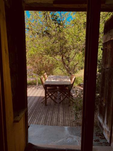 une table et des chaises sur un porche en bois avec une table et des chaises dans l'établissement Le Mouton Rouge - Superbe appartement avec terrasse, à Séez