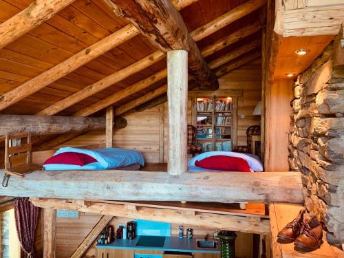 une chambre dans une cabane en rondins avec deux lits dans l'établissement Le Mouton Rouge - Superbe appartement avec terrasse, à Séez